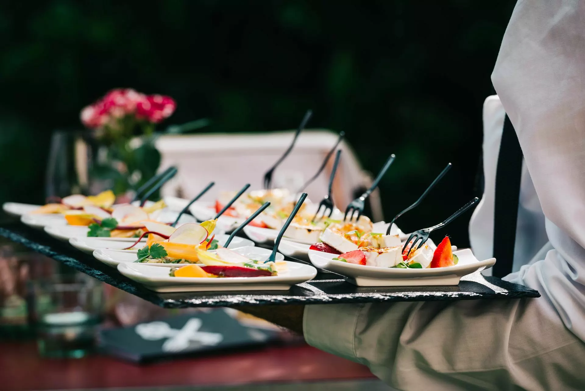 Elegant hors d'oeuvres served on slate at a premium outdoor event